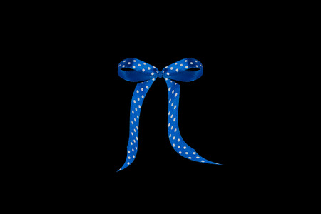 blue polka dot ribbon with a bow on a black backgroundの写真素材