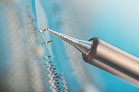 Soldering of electronic circuit board with electronic components. Soldering station. Engineers...