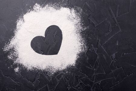 Scattered flour on the table. View from above. Heart. Place for text.の写真素材