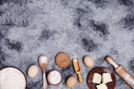 Eggs and flour and on a dark background.