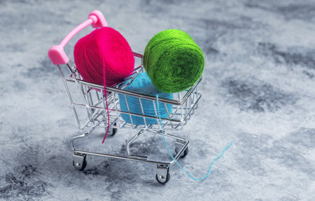 Shopping basket on wheels. The colored threads are red, green and blue.の写真素材