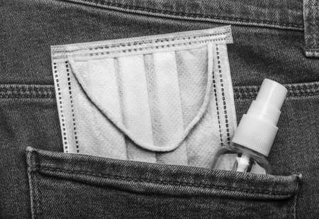 Medical mask and antiseptic in jeans pocket.