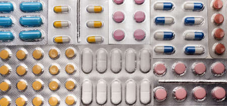 A bunch of medical pills in white, blue and other colors. Tablets in blisters.