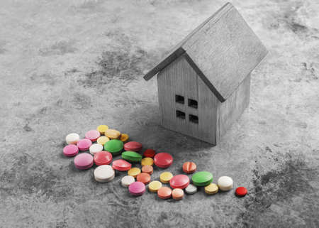 Medical concept. Old wooden house and pills.の写真素材
