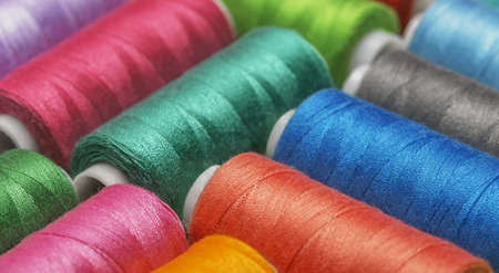 Colored threads on bobbins blue, green, red.