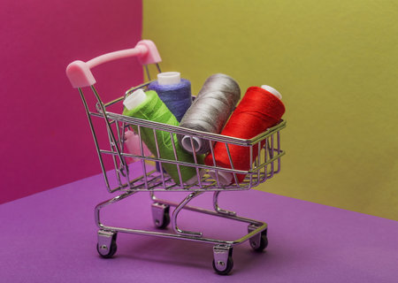 Shopping basket on wheels. Sewing threads on bobbins.の写真素材