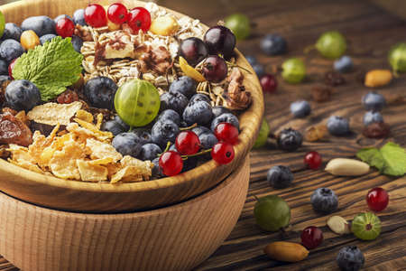 bowl of mint, nuts, berries, oatmeal and raisins.の写真素材