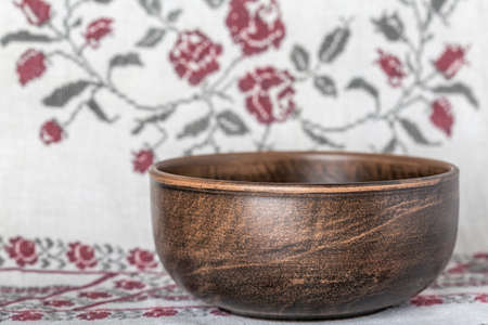 Rustic ceramic clay cup on an embroidered tablecloth.の写真素材