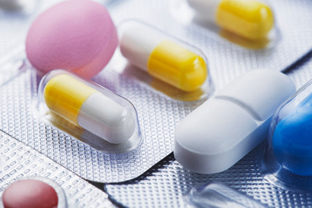 Heap of medical pills in white, blue and other colors. Pills in plastic package. Concept of healthcare and medicine.の写真素材