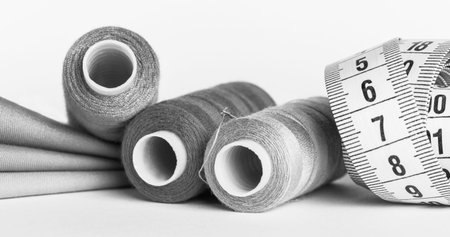 sewing thread pieces of fabric and centimeter tape in monochrome