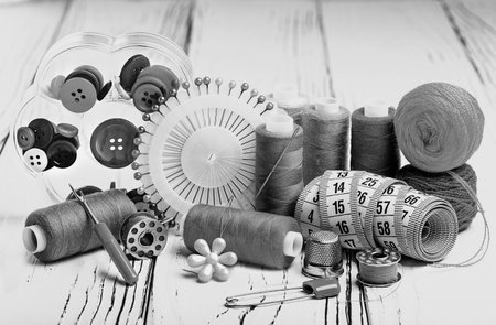 sewing kit of threads, buttons, sewing needle and measuring tape in monochromeの写真素材