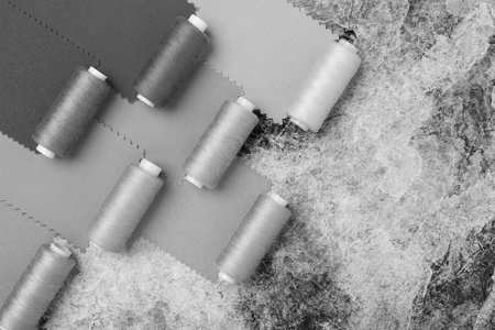 Sewing threads on bobbins. On a black and white background. Place for text.の写真素材