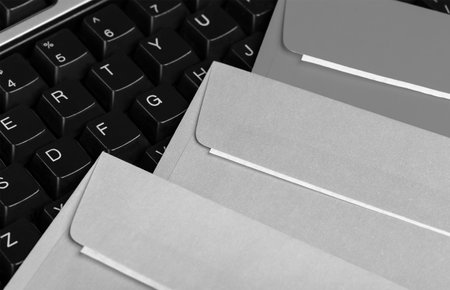 kraft paper envelopes and emails with computer keyboard