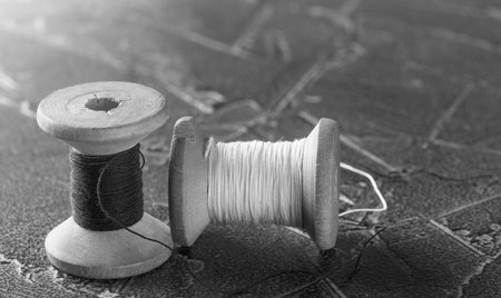 sewing thread on an old wooden spool in vintage styleの写真素材