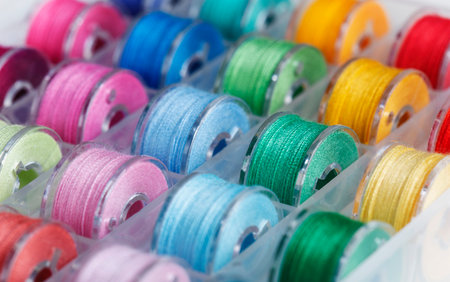 Plastic bobbins for a sewing machine with multi-colored threads.の写真素材
