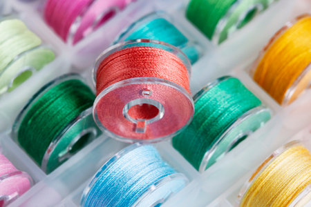 Plastic bobbins for a sewing machine with multi-colored threads.の写真素材