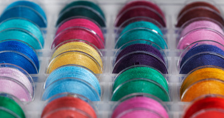 Plastic bobbins for a sewing machine with multi-colored threads.の写真素材