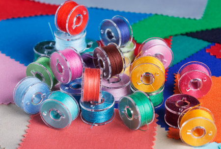 Plastic bobbins for a sewing machine with multi-colored threads.の写真素材