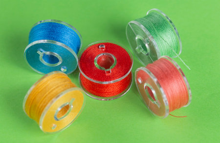 Plastic bobbins for a sewing machine with multi-colored threads.の写真素材