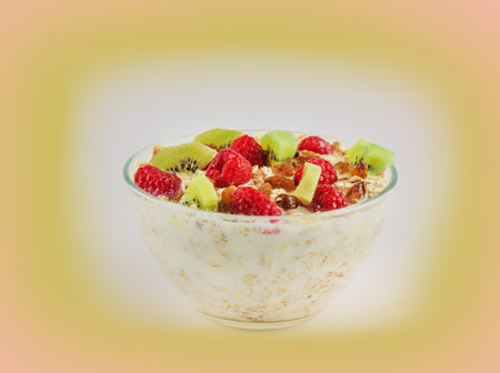 muesli with raspberries and kiwi in a bowl with milkの写真素材