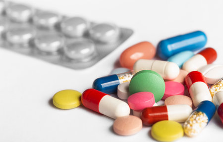 Yellow, green, blue and white medical tablets. Tablets in plastic packaging.の写真素材