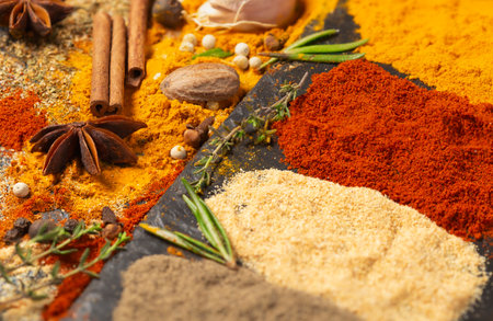 Scattered spices: turmeric, paprika, cardamom, nutmeg, black and allspiceの写真素材