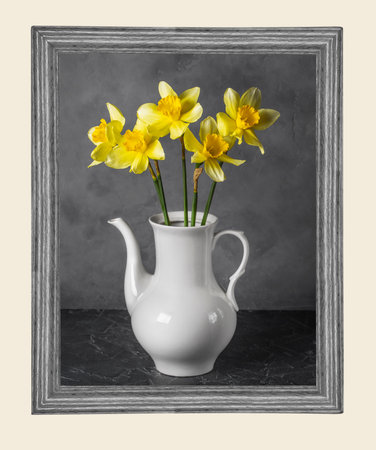 bouquet of yellow daffodils in a light vase in a wooden frameの写真素材