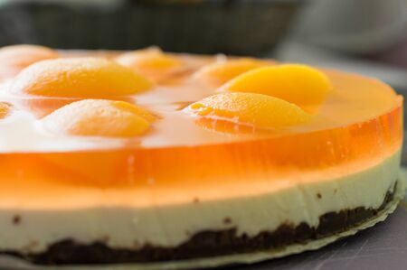 Homemade cheesecake with fresh apricot slices on the tableの写真素材