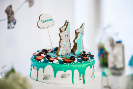 White cake decorated with blue fondant and cookies in the form of bearsの写真素材