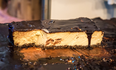 piece of cheesecake with chocolate frosting on saleの写真素材