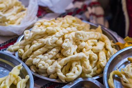 braided white cheese on a plate for saleの写真素材