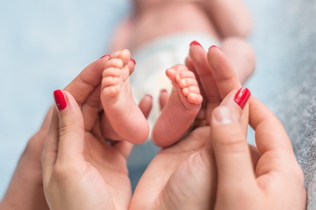 Baby feet in mother handsの写真素材
