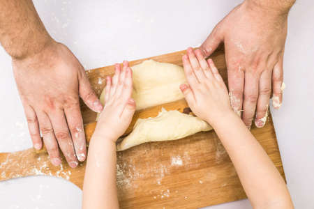 Children and dad hands rolled doughの写真素材