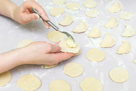Side view woman's hands make dumpling on tableの写真素材