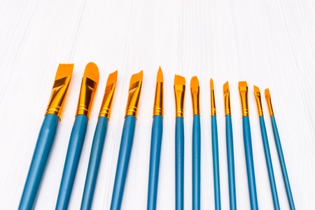 Brushes on white wooden background