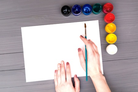 Hand holds brush over sheet