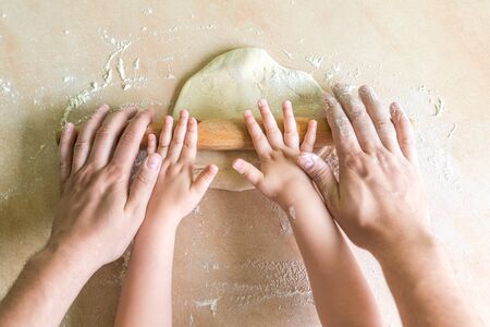 Children and dad hands rolled doughの写真素材
