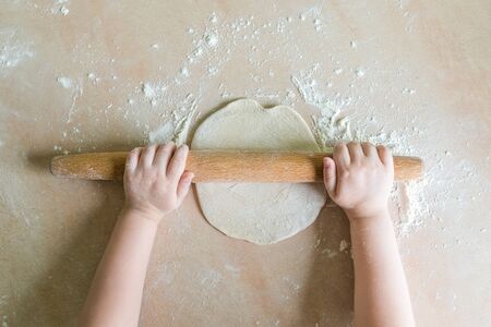 Childrens hands rolled doughの写真素材