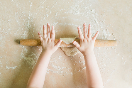 Childrens hands rolled doughの写真素材