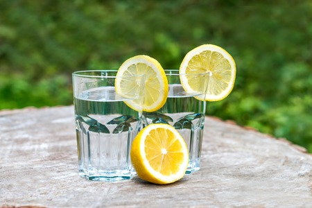 The slices of lemon on a two glasses of waterの写真素材