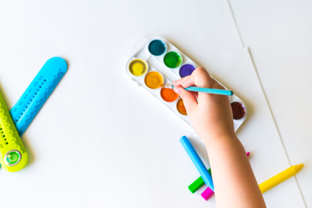 The child holds the brush over the paletteの写真素材