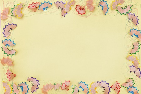A frame made of colored pencil shavings a on a yellow paperの写真素材