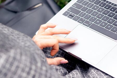 Close up of woman's hand and finger using touchpad of laptop. Female hand is using a touchpad on a laptop close up. Lifestyle and technology concept.の写真素材