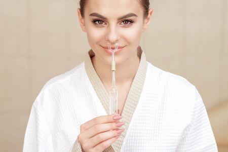 Nasal inhalation for essential oil Maholda in nose of smiling young woman close up.の写真素材
