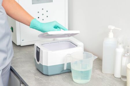 Doctor disinfects the tool. Cleaning systems for medical instruments. Ultrasonic cleaner.