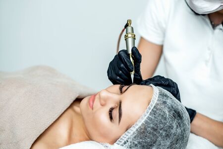 Permanent make up on eyebrows by professional cosmetologist.の写真素材