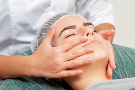 Face massage of woman young woman at beauty salon.の写真素材