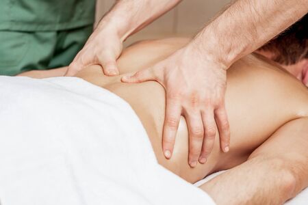 Back massage on back of man in spa salon.の写真素材