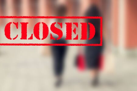 Word CLOSED on background of two young women in the shopping mall. Coronavirus quarantine. Closed shopping mall.の写真素材