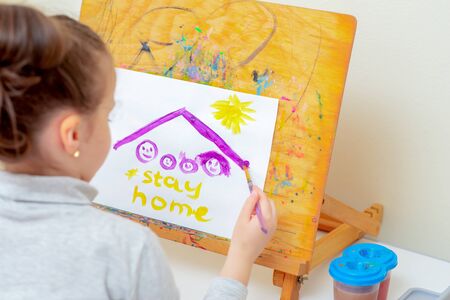 Child is drawing picture of family sketch under roof and words Stay Home with watercolors on white...